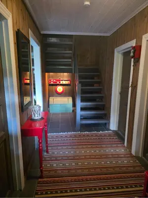 a staircase in a building with a red table and a red table sidx sidx at Kilodden, Lakeside Mountain Cabin with Stunning Views in Tuddal