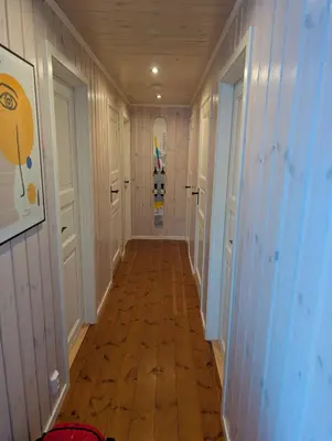 a hallway with white walls and a wooden floor at Håvi Solsiden 11C in Trysil