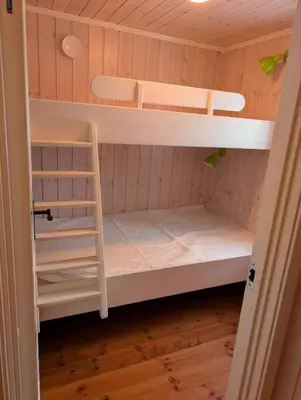 a bunk bed room with two bunk beds and a ladder at Håvi Solsiden 11C in Trysil