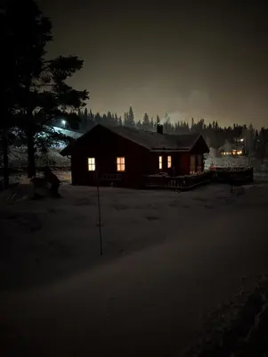 a log cabin at night with its lights on at Håvi Solsiden 11C in Trysil