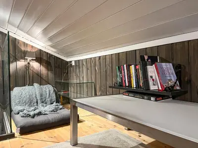 a living room with a bench with books on it at Bjønabakkens oase in Beitostøl
