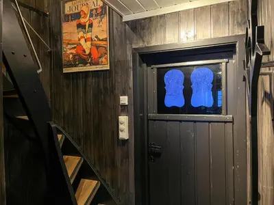 a room with a door and a staircase with a movie poster at Bjønabakkens oase in Beitostøl