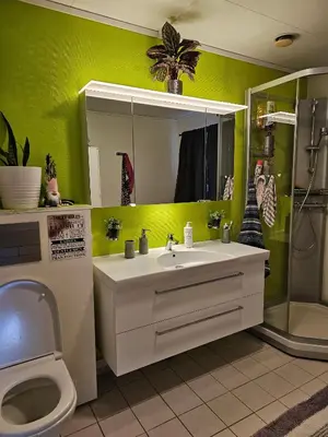 a bathroom with a sink and a toilet and a mirror at Charming and cozy house in Vindafjord in Dørheim
