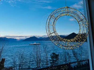a view of a ferris wheel with a boat in the water at Look at this view! 3 BR house overlooking Hardangerfjorden in Kvam