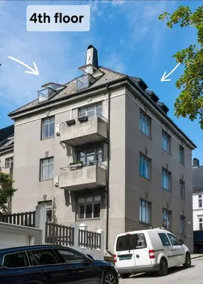 a building with two cars parked in front of it at Topp floor apartment with one bedroom & a loft in Ålesund