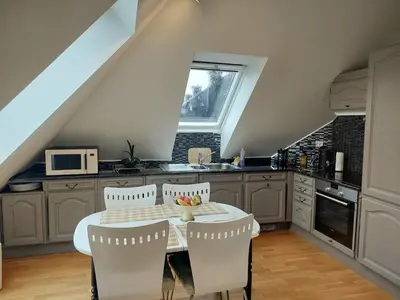 a kitchen with a table and chairs in a kitchen at Topp floor apartment with one bedroom & a loft in Ålesund