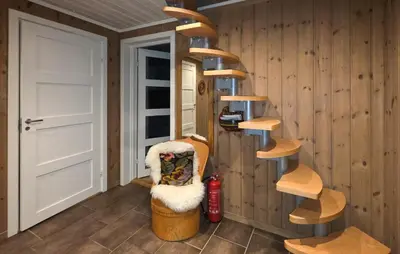 a room with a wooden wall with a spiral staircase at Cozy Home In Rauland With Sauna in Rauland