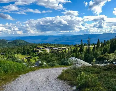 a gravel road leading to a village in the mountains at Cabin By Main Ski Trail At Norefjell in Eggedal