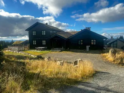 a large black house with a barn at Family Cabin With Views Of Jotunheimen in Øyer