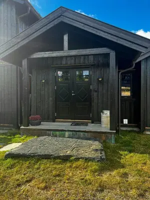 a wooden shed with a door and a porch at Family Cabin With Views Of Jotunheimen in Øyer