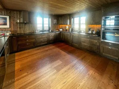 a large kitchen with wooden cabinets and a wooden floor at Family Cabin With Views Of Jotunheimen in Øyer