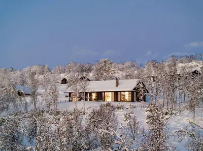 a house in the snow with snow covered trees at Architect-Designed Cabin With Ski Trail Near Geilo in Ål
