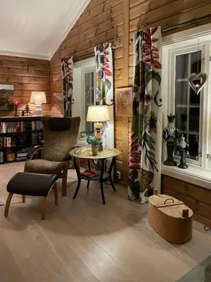 a living room with a table and a chair at Family-Built Cabin At The Three Line in Eggedal