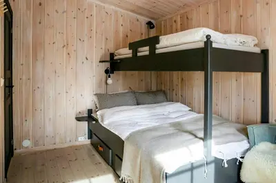 a bedroom with two bunk beds in a wooden wall at Cabin With Panoramic Views Of Jotunheimen in Gålå