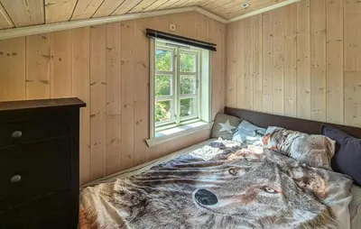 a bedroom with a wolf comforter on a bed at Cosy Cabin With Jacuzzi Right By The Ski Slope in Norheimsund