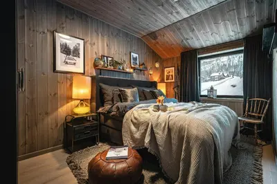 a bedroom with a bed in a wooden wall at Two-Storey Penthouse By Hemsedal Ski Resort in Hemsedal