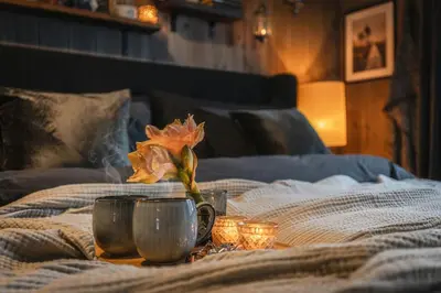 a table with two cups and a flower on a bed at Two-Storey Penthouse By Hemsedal Ski Resort in Hemsedal