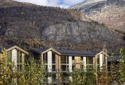 a large house in front of a mountain at Two-Storey Penthouse By Hemsedal Ski Resort in Hemsedal