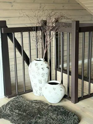 two white vases sitting next to a railing at Mountain Cabin With Sauna Atop Fageråsen in Trysil
