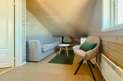 a living room with a couch and a chair at Mountain Cabin With Sauna Atop Fageråsen in Trysil