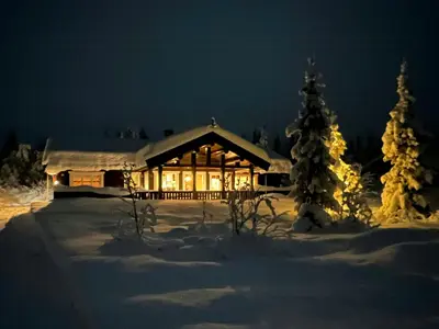 a log cabin in the snow at night at Mountain Cabin With Cinema Near Synnfjellporten in Nord Torpa