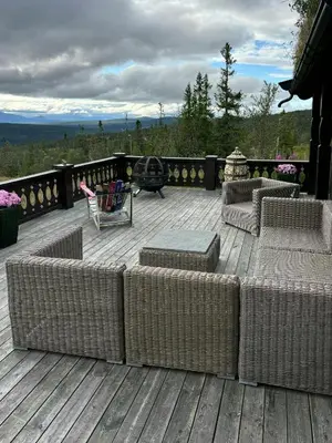 a deck with chairs and couches on a wooden deck at Mountain Cabin By Femunden Facing Sølen in Nymoen