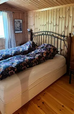a bed in a room with a wooden floor at Mountain Cabin By Femunden Facing Sølen in Nymoen