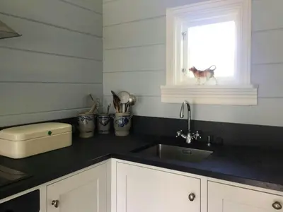a kitchen with a sink and a dog in a window at Historic Timber House From The 1800S In Nordfjord in Olden