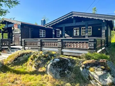 a blue house with a wooden fence in front of it at Modernised Cabin By The Ski Lift In Hovden in Bykle