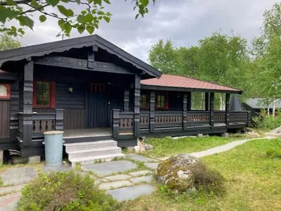 a small building with a porch and stairs in a yard at Modernised Cabin By The Ski Lift In Hovden in Bykle