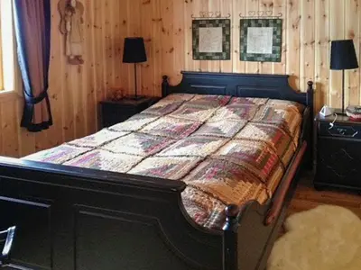 a bed in a bedroom with a wooden wall at Modernised Cabin By The Ski Lift In Hovden in Bykle