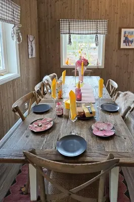 a wooden table with plates and glasses on it at Mountain Cabin With Ski Access In Høgevarde in Flå