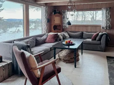 a living room with a couch and a table at Handmade Cabin By Pond On Golsfjellet in Gol