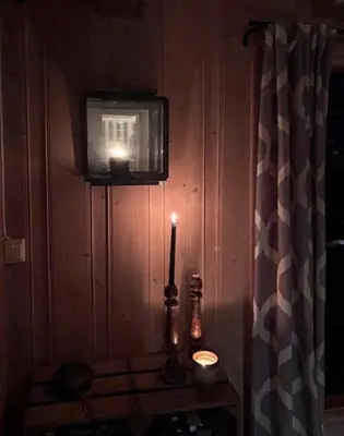 a room with a television and a candle on a table at Handmade Cabin By Pond On Golsfjellet in Gol