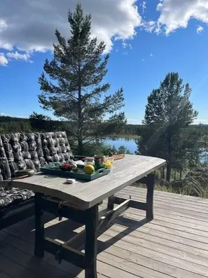 a wooden table with a tray of fruit on a deck at Handmade Cabin By Pond On Golsfjellet in Gol