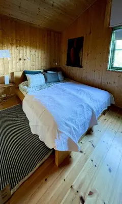 a bedroom with a large bed in a wooden room at Unique Cabin And Freestanding Sauna With Views in Aurdal