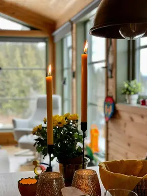 a table with two candles and flowers on it at Unique Cabin And Freestanding Sauna With Views in Aurdal