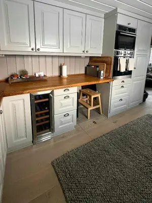 a kitchen with white cabinets and a wooden counter top at Cottage Near Grønnsenknipa With Skiing And Hiking in Ron