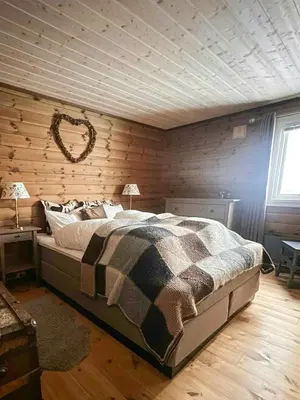 a bedroom with a bed and a wooden wall at Cottage Near Grønnsenknipa With Skiing And Hiking in Ron