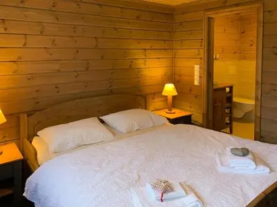 a bedroom with a bed in a wooden wall at Elegant Mountain Cabin With Kjerringafjell View in Brekka