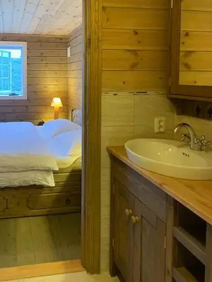 a bathroom with a sink and a bed in a room at Elegant Mountain Cabin With Kjerringafjell View in Brekka