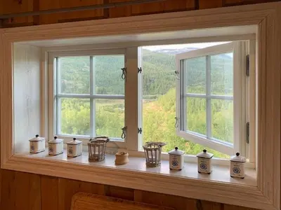 a window with a bunch of vases on a window sill at Elegant Mountain Cabin With Kjerringafjell View in Brekka