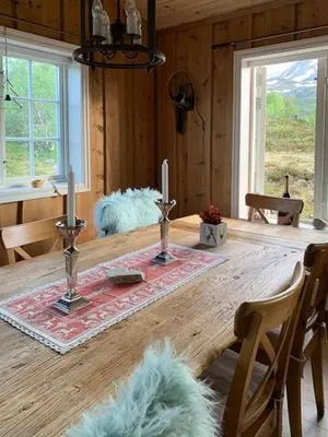 a wooden table with two candles on top of it at Elegant Mountain Cabin With Kjerringafjell View in Brekka