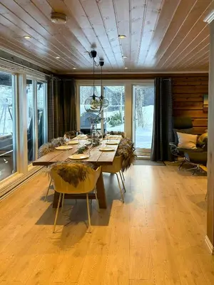 a dining room with a large wooden table and chairs at Timber Cabin With Outdoor Spa Near Stranda in Brunstad