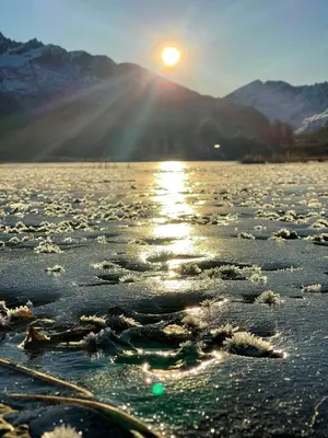 a sunset over a body of water with the sun shining on it at Timber Cabin With Outdoor Spa Near Stranda in Brunstad