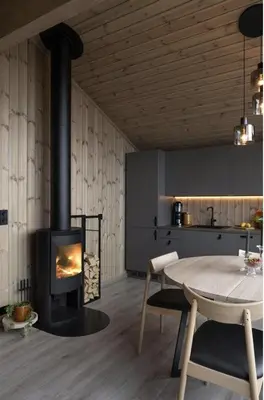 a kitchen with a table and a wood stove at New Cabin At Norefjell With Mountain Panorama in Noresund