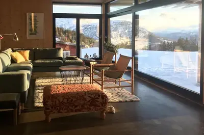 a living room with a couch and chairs and a large window at Villa Vetleskog On Mollandsmarki In Sogn in Hafslo