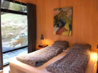 a bedroom with two beds and a large window at Villa Vetleskog On Mollandsmarki In Sogn in Hafslo