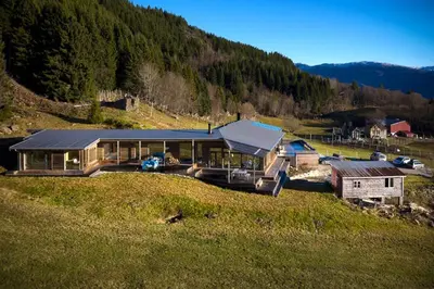 a large house on top of a grassy hill at Villa Vetleskog On Mollandsmarki In Sogn in Hafslo