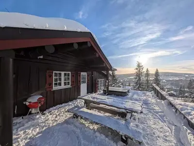 a building with snow on the ground next to at Log Cabin With Panoramic Views At Skeikampen in Svingvoll